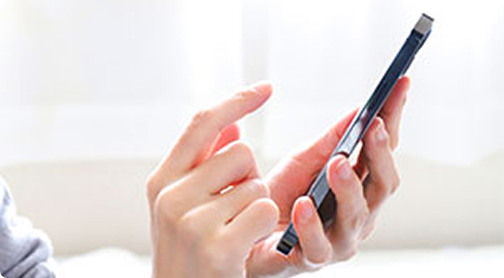 スマートフォンで診療日を予約する人のイメージ