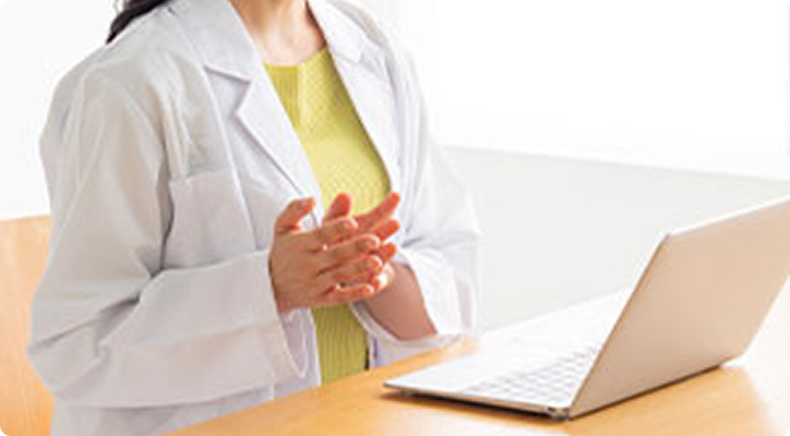 パソコンを使ってオンライン診療を行う医師のイメージ